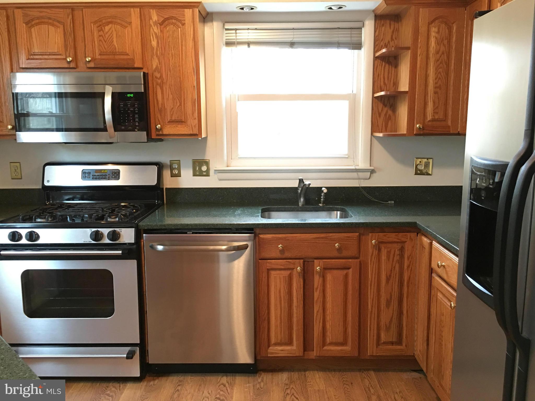 4307 Havard Street Silver Spring, MD 20906 - Photo 3 of 27 a kitchen with granite countertop a refrigerator stove and microwave