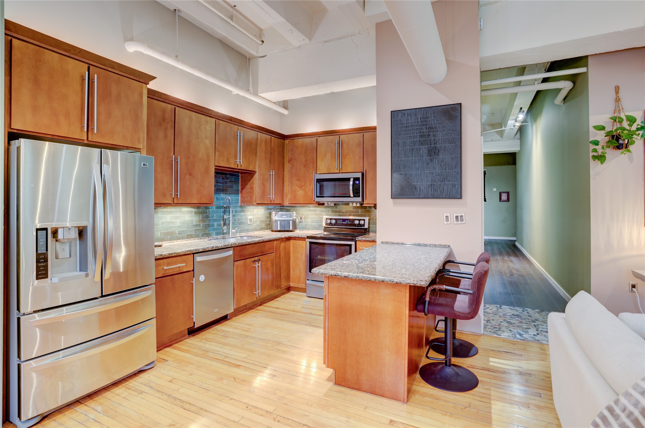 705 Main Street, Unit 419 Houston, TX 77002 - Photo 5 of 25 a kitchen with stainless steel appliances kitchen island granite countertop a refrigerator a stove a sink dishwasher with a dining table and chairs