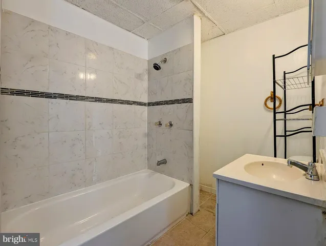 a bathroom with a tub a sink and a shower