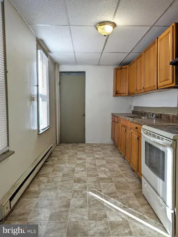 a kitchen with granite countertop a stove a sink and a refrigerator
