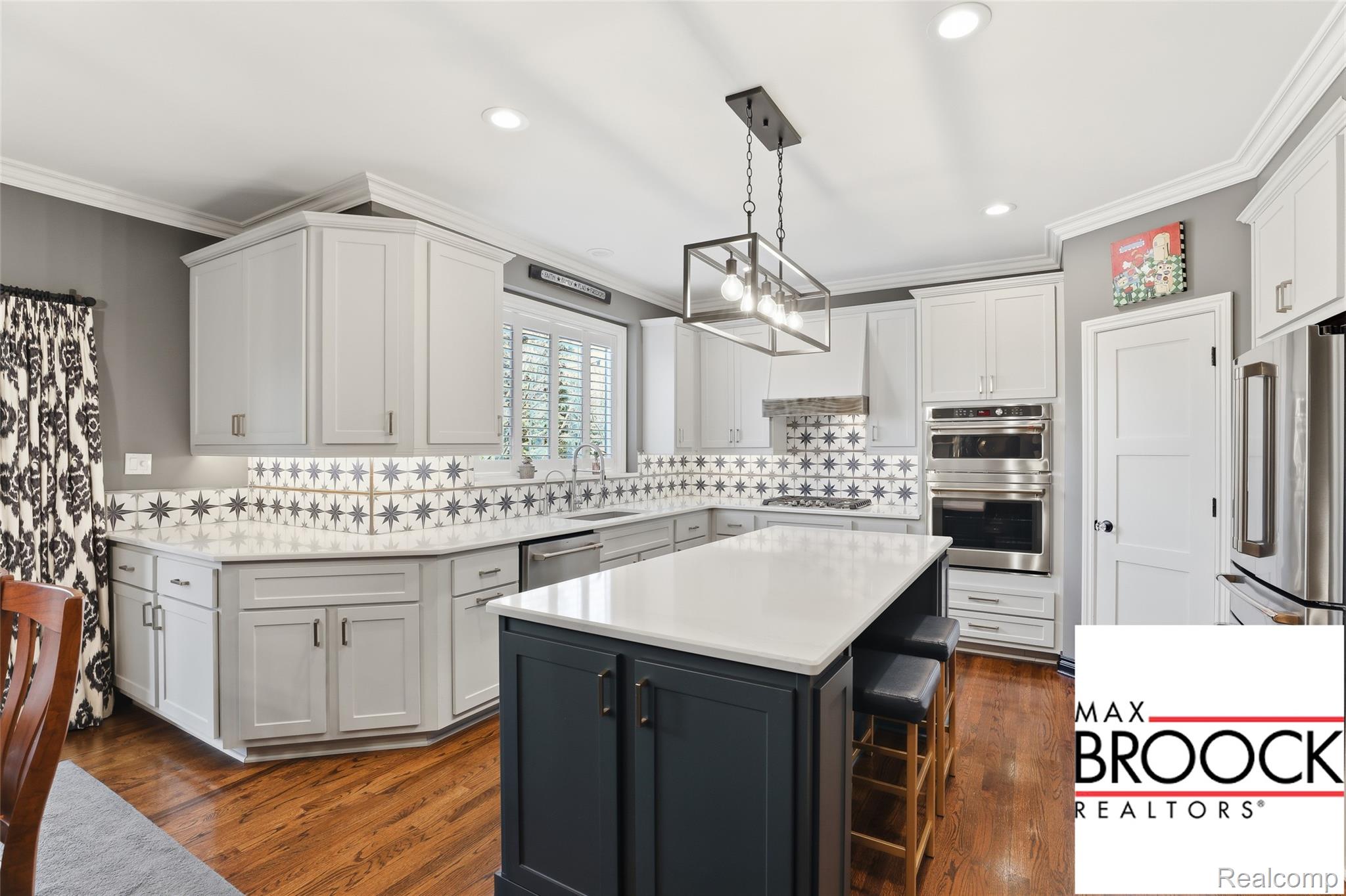 668 Springview Drive Rochester, MI 48307 - Photo 27 of 90 Kitchen with ornamental molding, decorative backsplash, stainless steel appliances, a kitchen bar, and hanging light fixtures