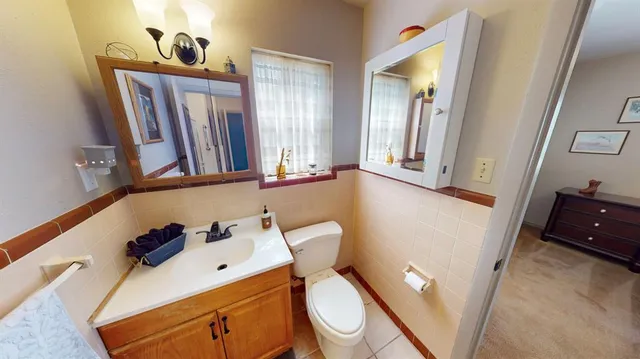 a bathroom with a toilet sink and mirror