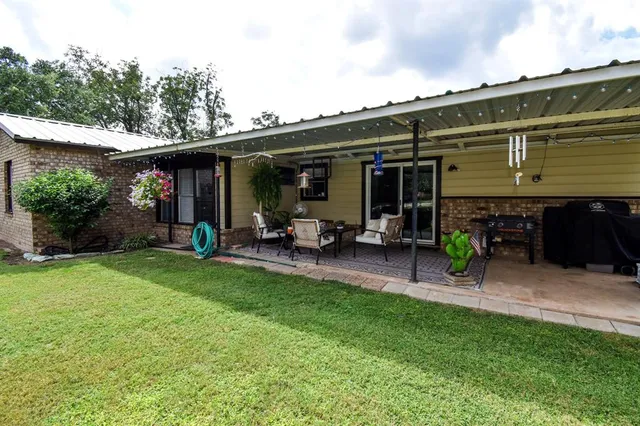 a view of a chair and table in backyard of the house