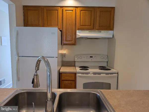 a kitchen with granite countertop a refrigerator sink and cabinets