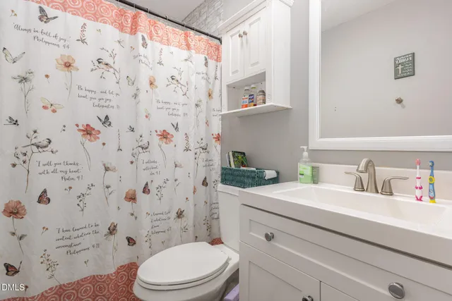a bathroom with a granite countertop toilet sink and mirror