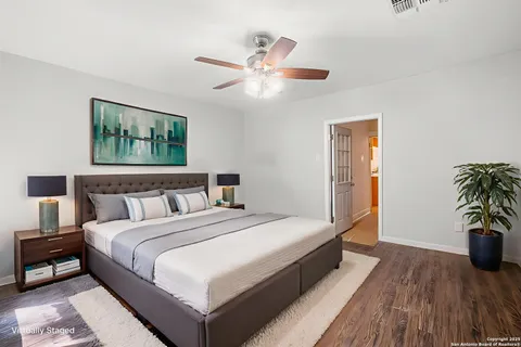 a spacious bedroom with a bed and a potted plant