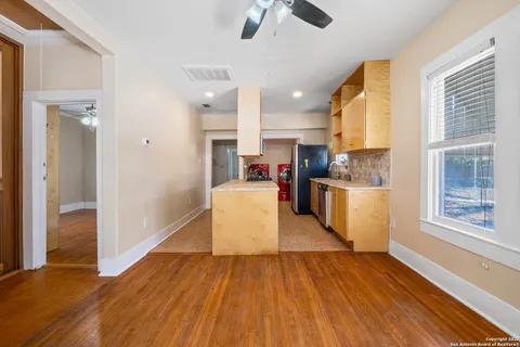 a large kitchen with cabinets wooden floor and stainless steel appliances
