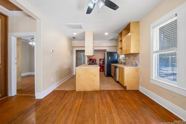 a large kitchen with cabinets wooden floor and stainless steel appliances