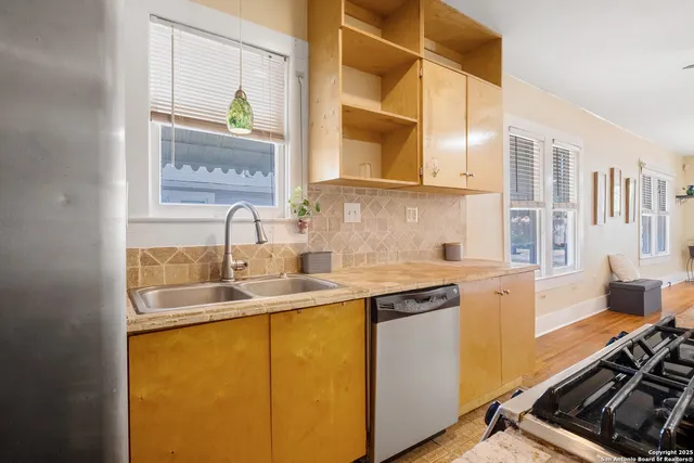 a kitchen with stainless steel appliances a sink a stove and a window