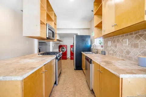 a kitchen with stainless steel appliances granite countertop a sink and a stove