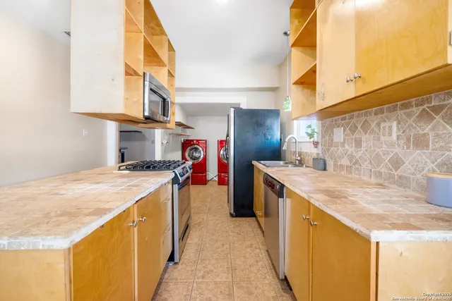 a kitchen with stainless steel appliances granite countertop a sink and a stove