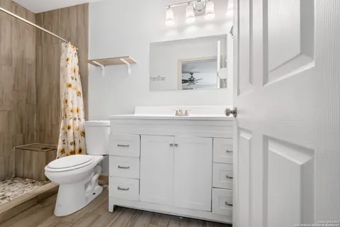 a bathroom with a sink toilet a mirror and shower