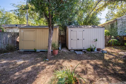 a view of a house with backyard and trees