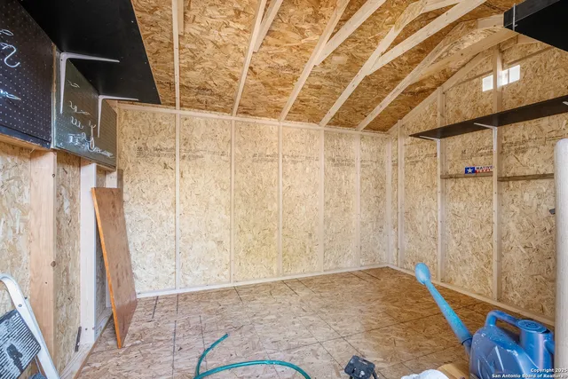 a view of a room with wooden walls and a wooden door