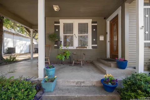 a garden with a table and chairs and potted plants