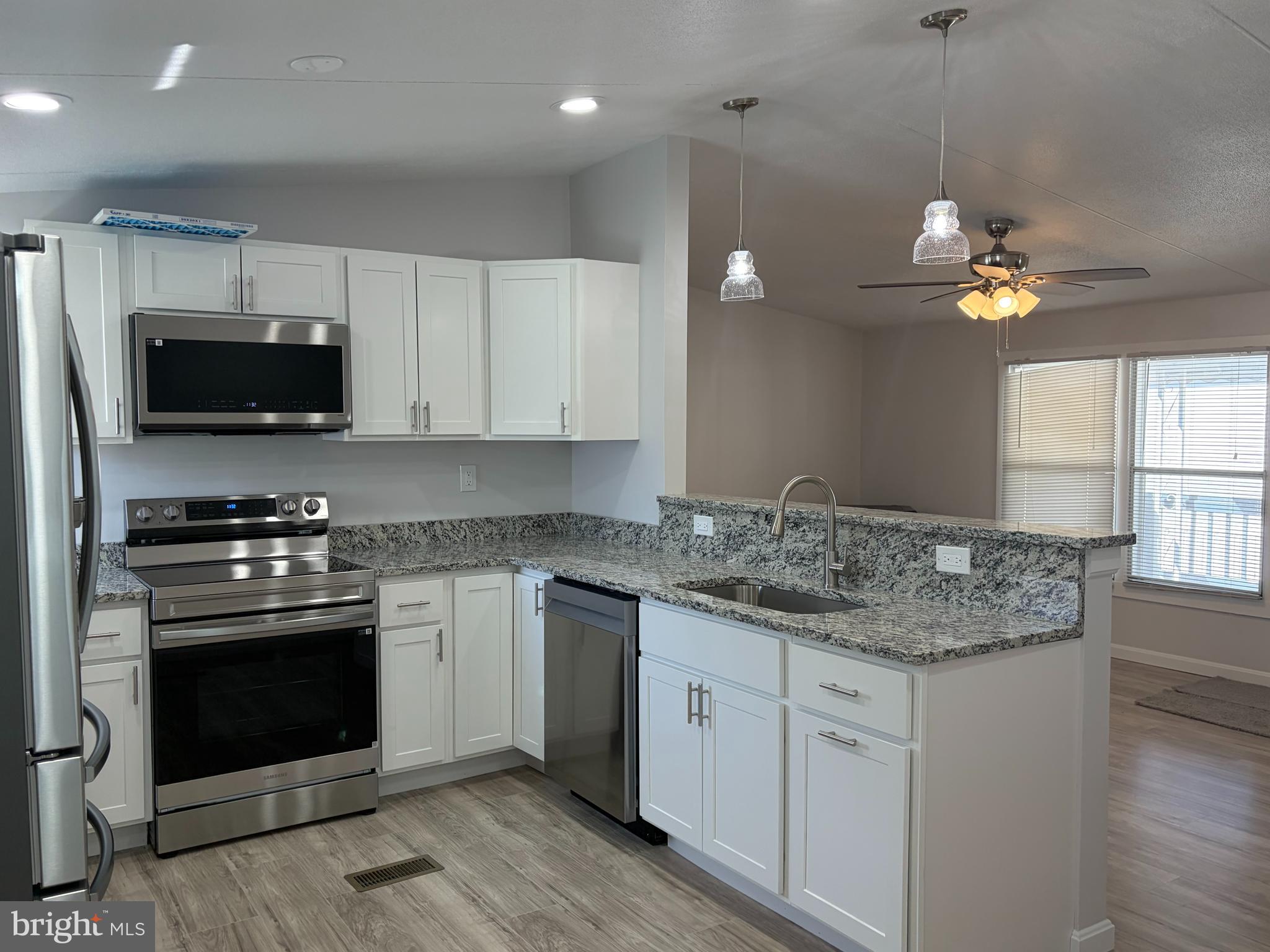 7 Roseview Road Dundalk, MD 21222 - Photo 2 of 13 a kitchen with kitchen island granite countertop stainless steel appliances a stove microwave and a sink
