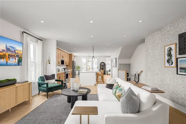 a living room with furniture and a dining table with kitchen view