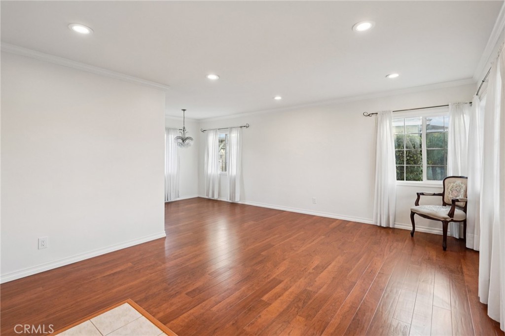 732 East Charron Place Compton, CA 90220 - Photo 6 of 24 an empty room with wooden floor and a window