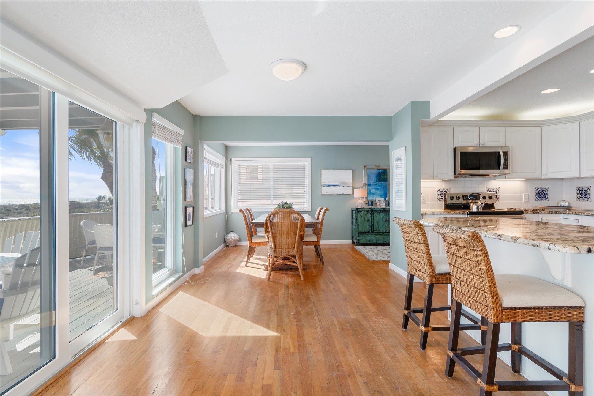 5512 Atlantic View St. Augustine, FL 32080 - Photo 11 of 77 Kitchen with light stone countertops, white cabinets, a kitchen breakfast bar, light wood-style floors, and stainless steel appliances
