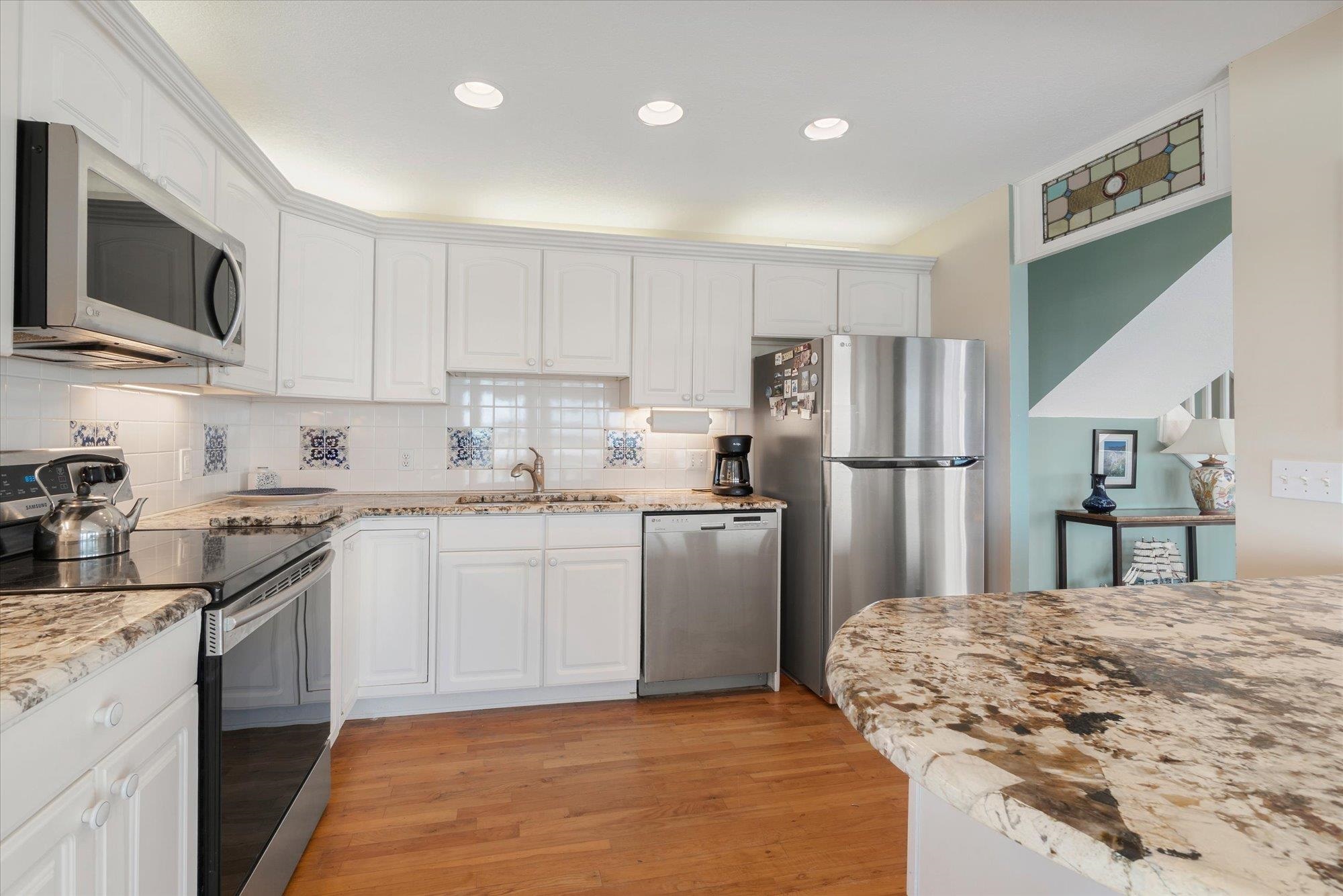 5512 Atlantic View St. Augustine, FL 32080 - Photo 14 of 77 Kitchen with stainless steel appliances, white cabinets, light wood-type flooring, tasteful backsplash, and recessed lighting