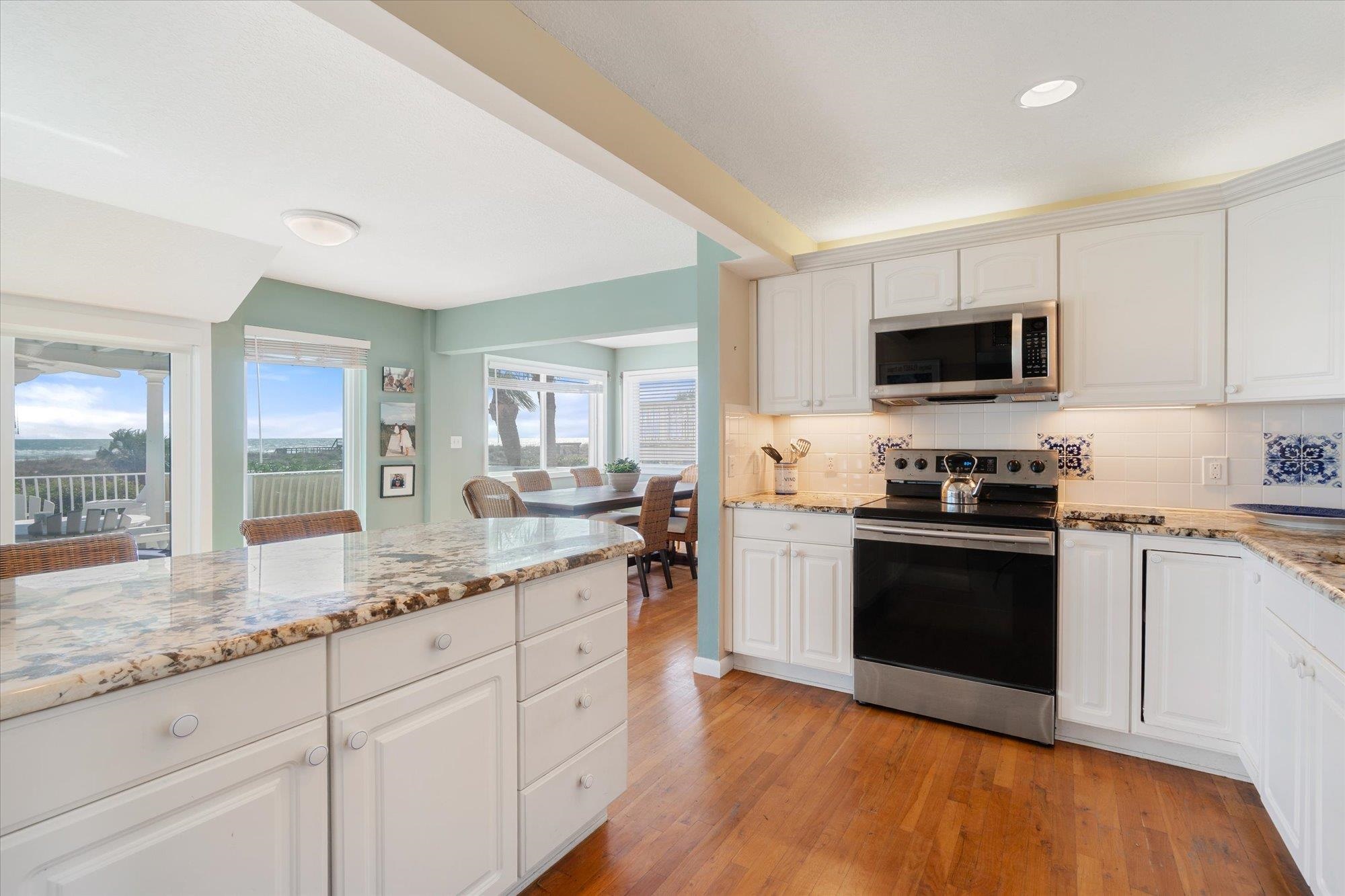5512 Atlantic View St. Augustine, FL 32080 - Photo 16 of 77 Kitchen featuring stainless steel appliances, light stone countertops, white cabinetry, light wood-style floors, and recessed lighting