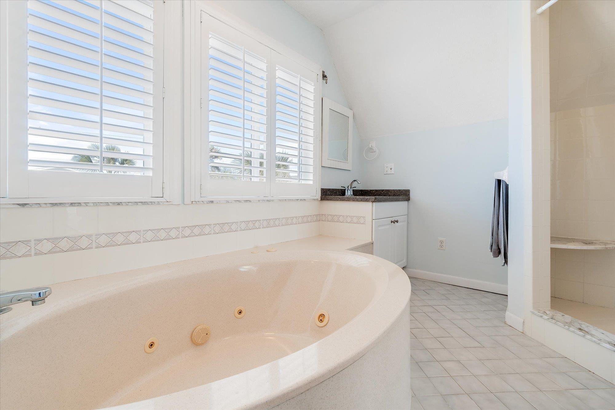 5512 Atlantic View St. Augustine, FL 32080 - Photo 24 of 77 Bathroom featuring vanity, a tub with jets, vaulted ceiling, tiled shower, and light tile patterned floors