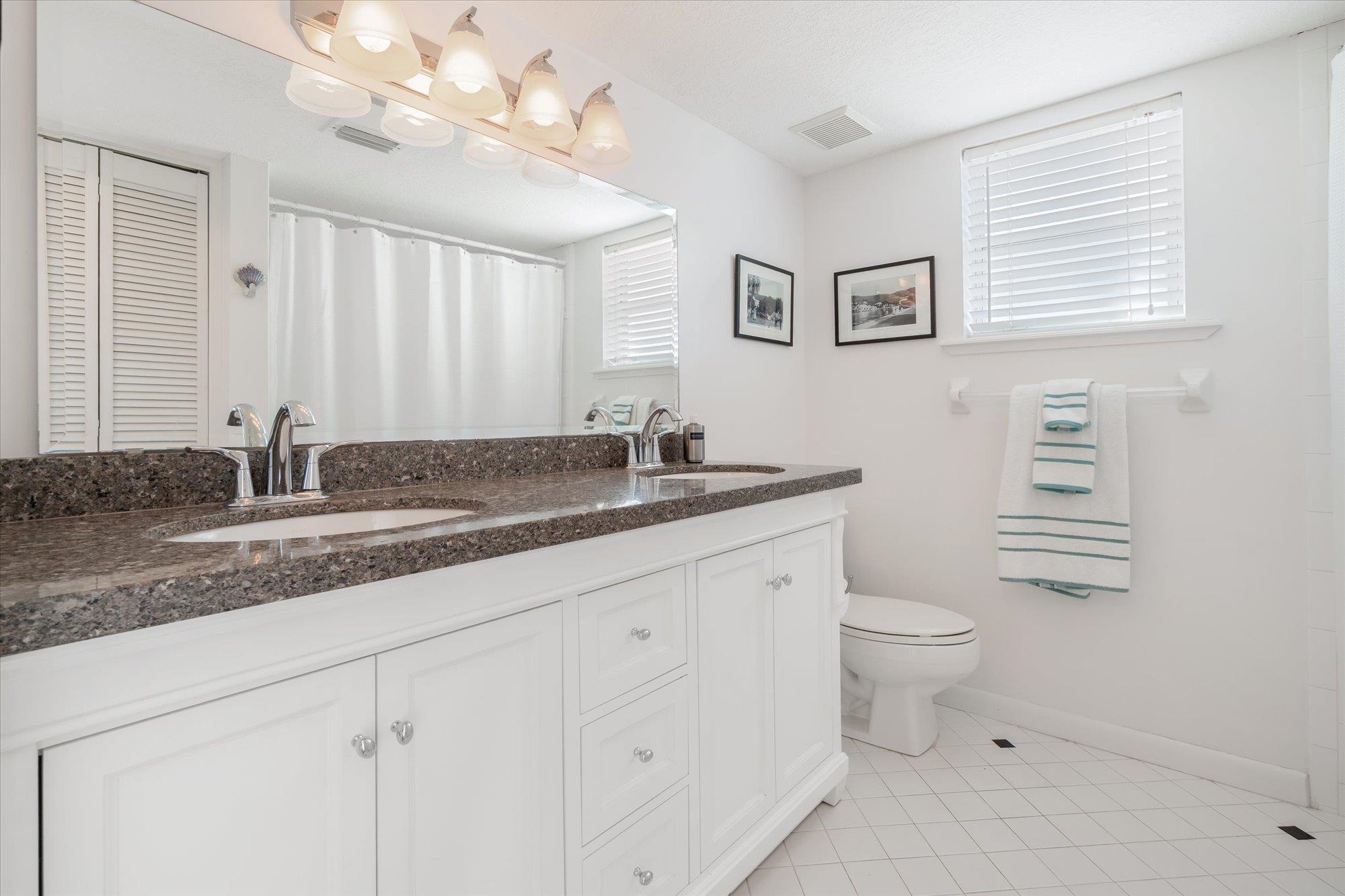 5512 Atlantic View St. Augustine, FL 32080 - Photo 32 of 77 Bathroom with a closet, double vanity, light tile patterned floors, and a shower with curtain