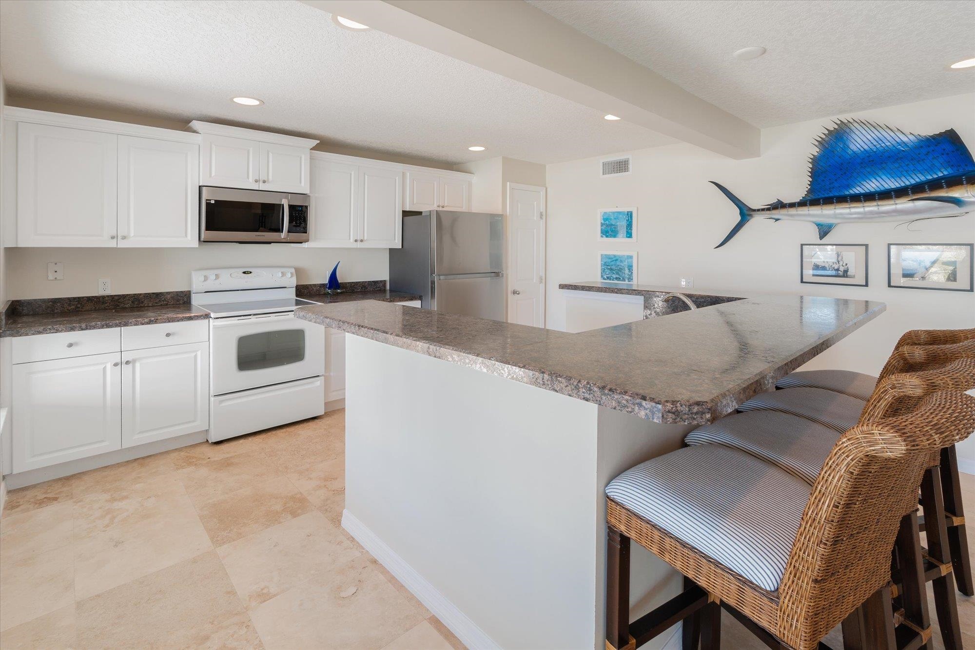 5512 Atlantic View St. Augustine, FL 32080 - Photo 38 of 77 Kitchen featuring stainless steel appliances, a kitchen bar, white cabinets, recessed lighting, and a textured ceiling