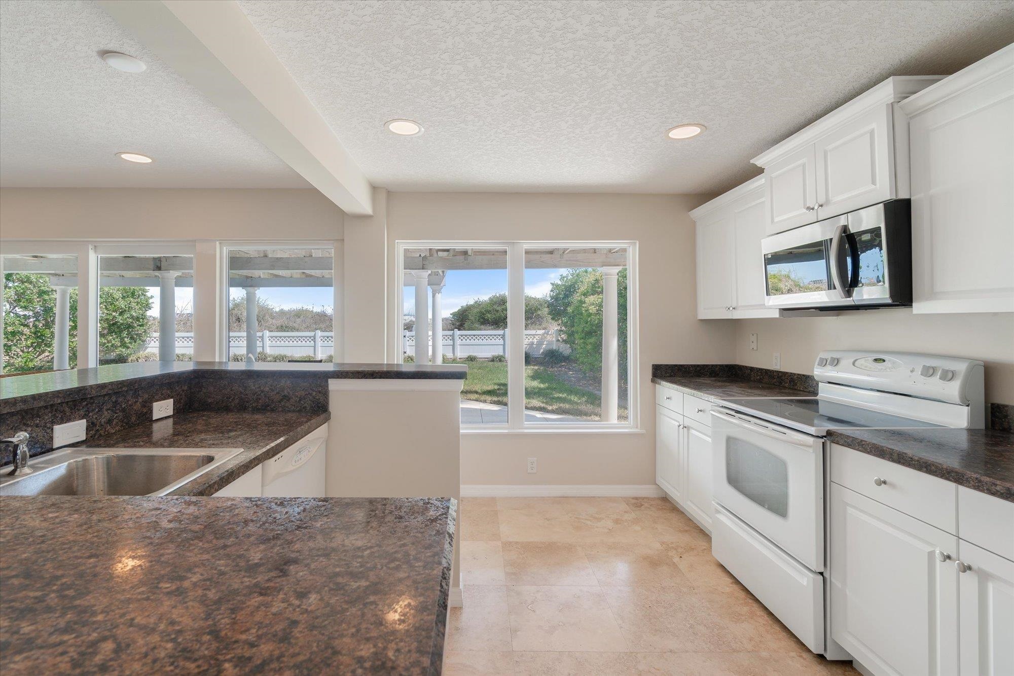 5512 Atlantic View St. Augustine, FL 32080 - Photo 39 of 77 Kitchen with white appliances, white cabinets, recessed lighting, a textured ceiling, and beamed ceiling