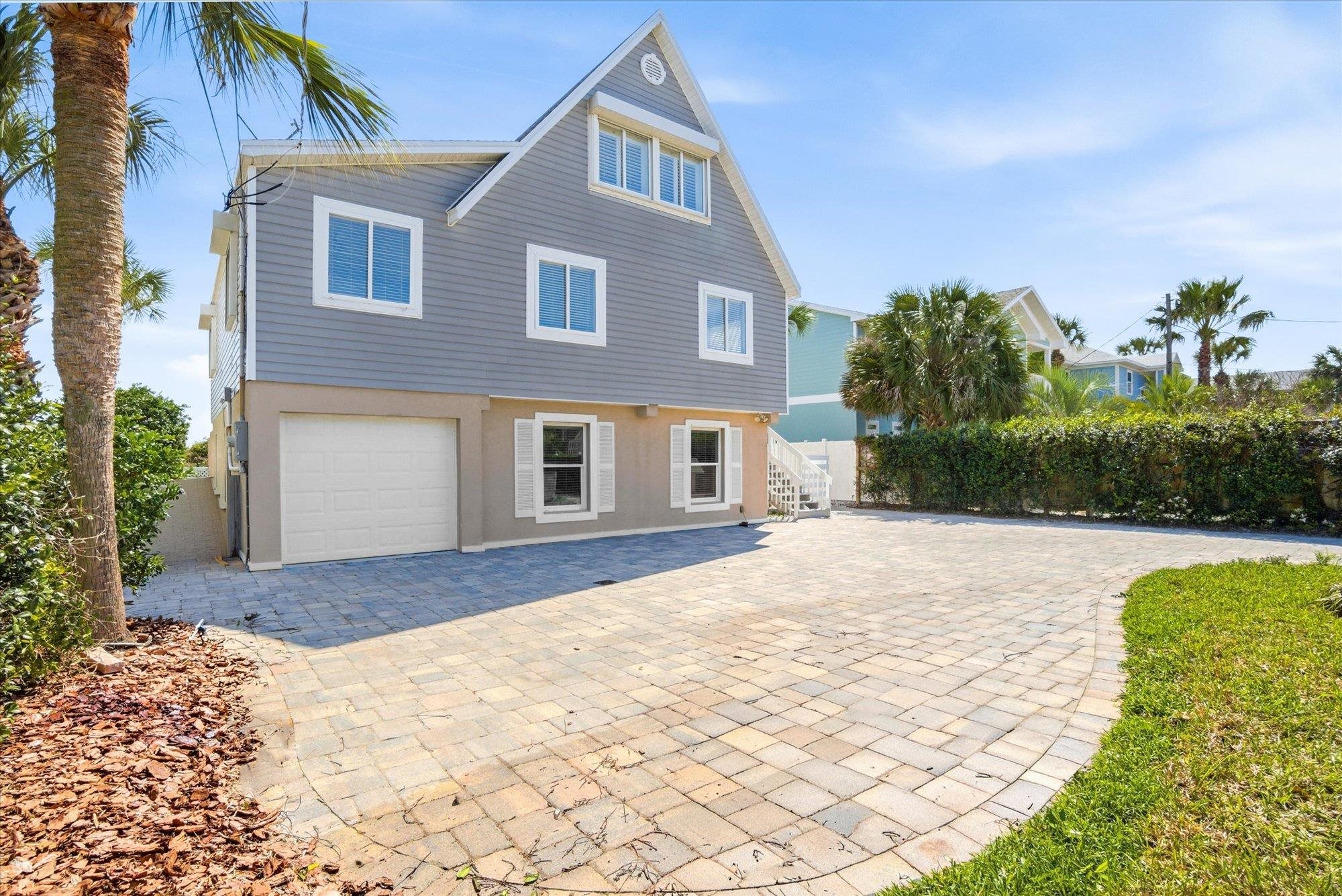 5512 Atlantic View St. Augustine, FL 32080 - Photo 73 of 77 Rear view of house with decorative driveway, an attached garage, and stucco siding