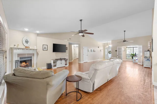 a kitchen with stainless steel appliances kitchen island granite countertop a table chairs sink and window