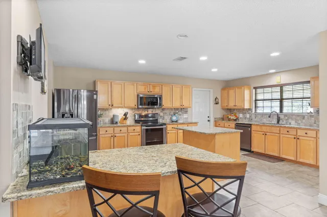 a kitchen with stainless steel appliances granite countertop a refrigerator sink and microwave