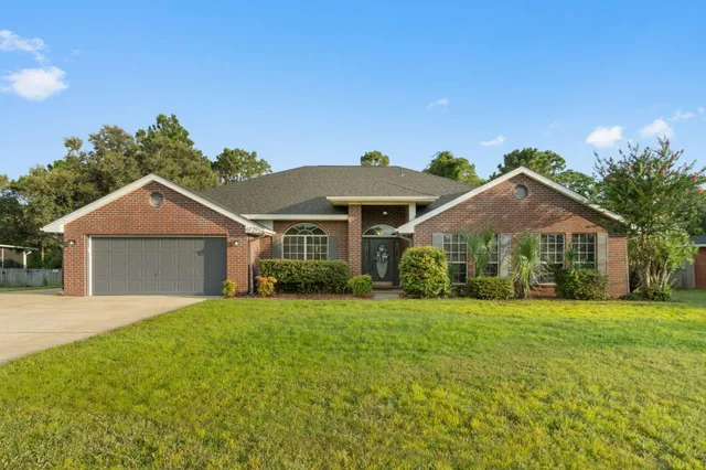 a front view of a house with yard and green space