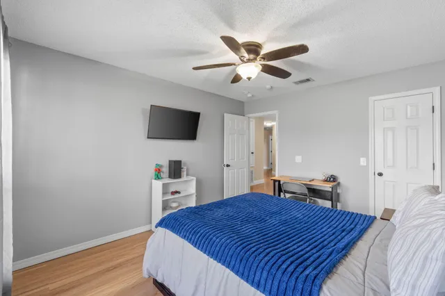 a spacious bedroom with a bed and a chandelier