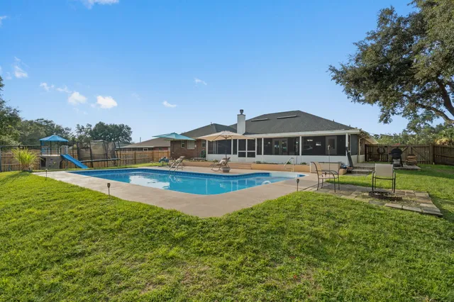 a view of a house with swimming pool and a yard