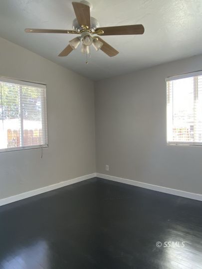 416 North Helena Street Ridgecrest, CA 93555 - Photo 15 of 22 an empty room with wooden floor fan and windows