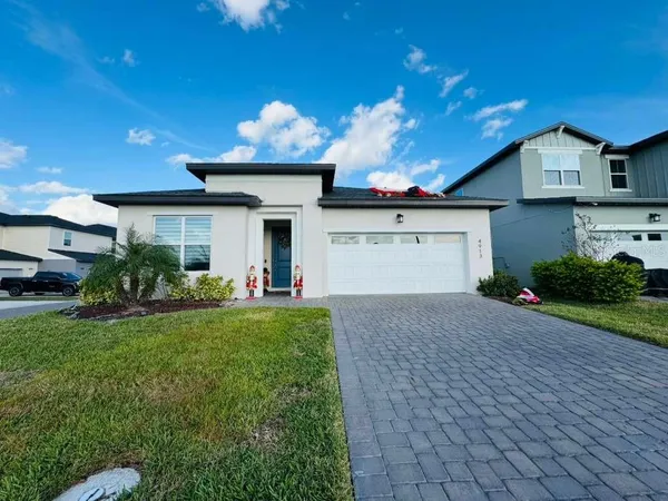 a front view of a house with a yard and a garage