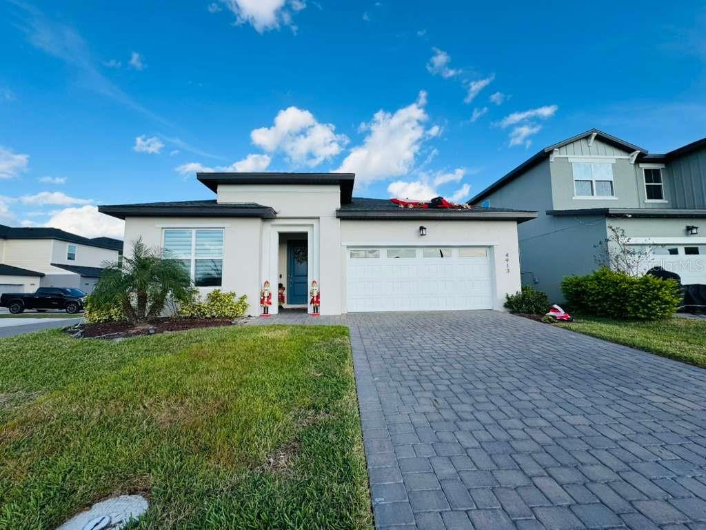 4913 Rain Shadow Drive St. Cloud, FL 34772 - Photo 1 of 22 a front view of a house with a yard and a garage