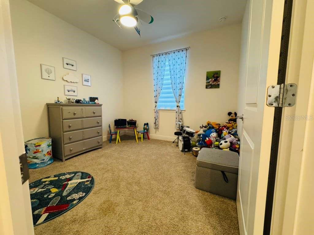 4913 Rain Shadow Drive St. Cloud, FL 34772 - Photo 11 of 22 a bedroom with a bed and a dresser