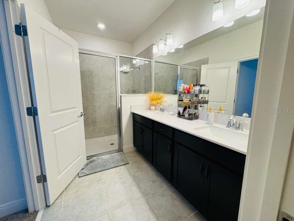 4913 Rain Shadow Drive St. Cloud, FL 34772 - Photo 16 of 22 a bathroom with a sink vanity tub and shower