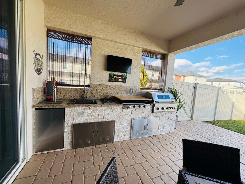 4913 Rain Shadow Drive St. Cloud, FL 34772 - Photo 18 of 22 a living room with stainless steel appliances kitchen island granite countertop a stove a sink and a microwave
