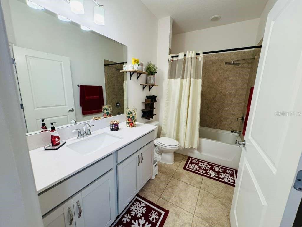 4913 Rain Shadow Drive St. Cloud, FL 34772 - Photo 10 of 22 a bathroom with a sink toilet double vanity and tub