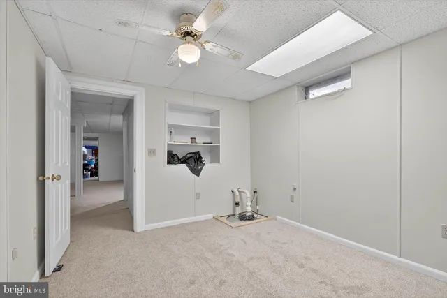 a view of an empty room with closet and mirrors