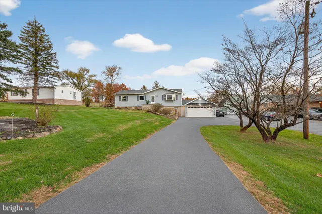 a view of a house with a yard and a tree