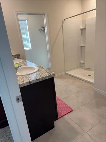 a bathroom with a granite countertop sink and shower