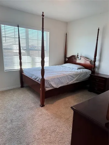 a bedroom with a bed and a window