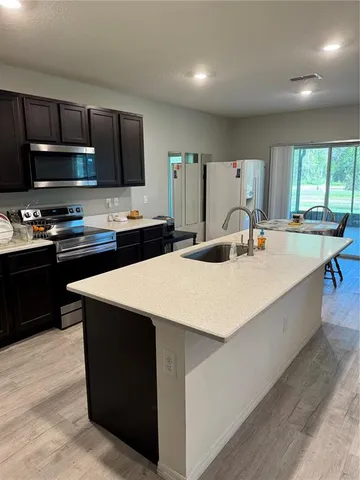 a kitchen with stainless steel appliances a sink stove and refrigerator