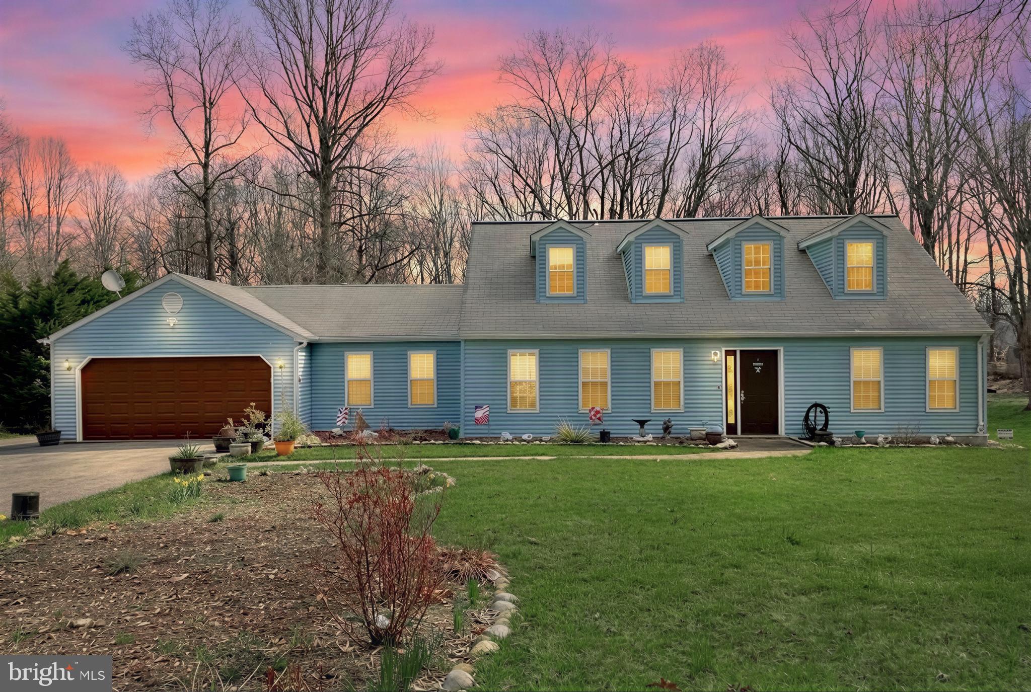 a front view of a house with a yard and trees