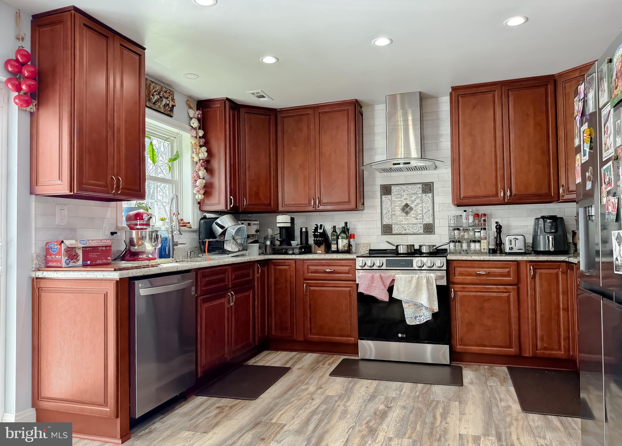 30150 Huntt Road Mechanicsville, MD 20659 - Photo 16 of 40 a kitchen with stainless steel appliances granite countertop wooden cabinets a stove top oven a sink and dishwasher with wooden floor