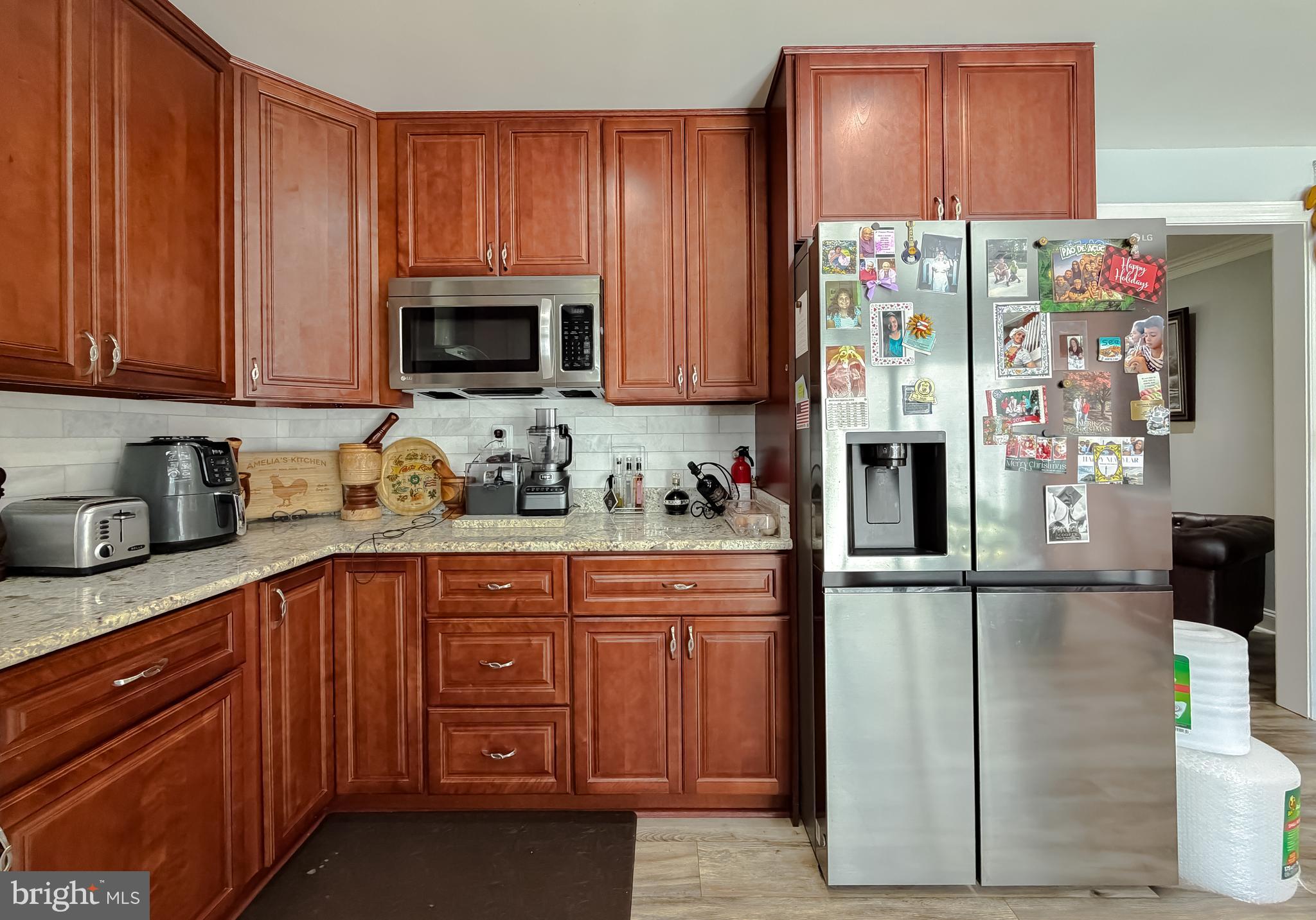 30150 Huntt Road Mechanicsville, MD 20659 - Photo 19 of 40 a kitchen with granite countertop wooden cabinets and a refrigerator